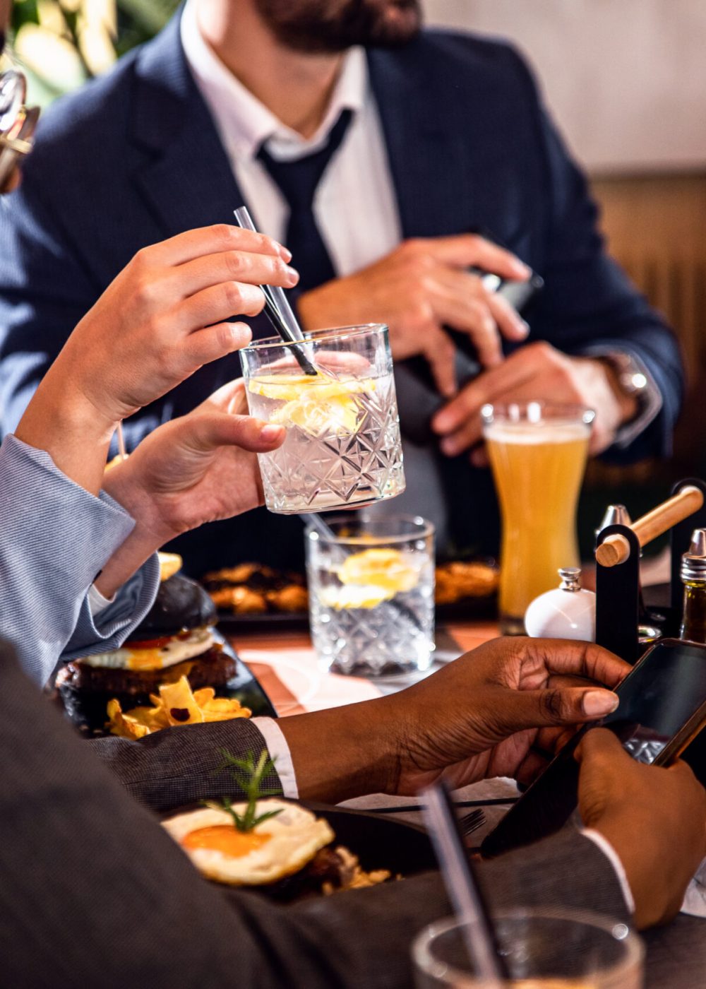 Hands of business people sitting in a restaurant at a business lunch.